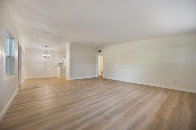 3813 Surrey Dr, Orlando, FL 32812 - unfurnished living room with a chandelier, light wood-type flooring, and baseboards