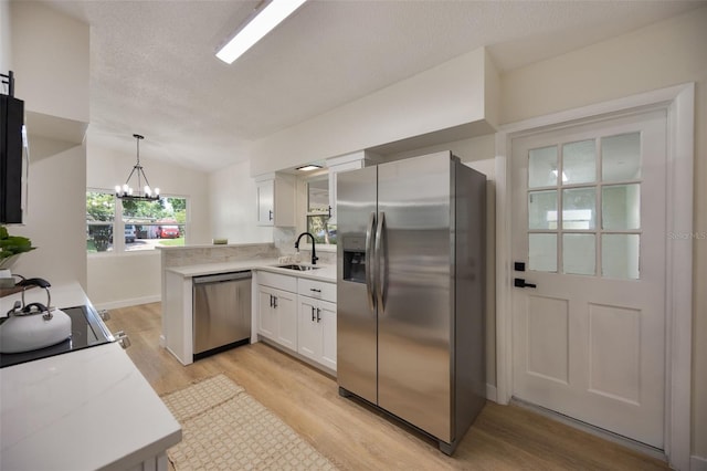 3813 Surrey Dr, Orlando, FL 32812 - kitchen with stainless steel appliances, light wood-style floors, a peninsula, a sink, and white cabinets