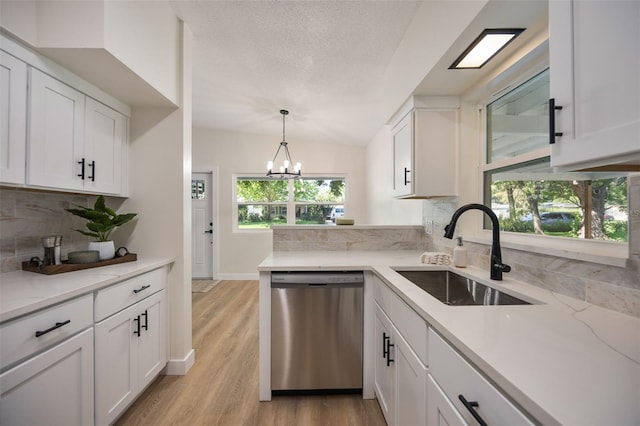 3813 Surrey Dr, Orlando, FL 32812 - kitchen with stainless steel dishwasher, a sink, tasteful backsplash, white cabinets, and light wood-type flooring