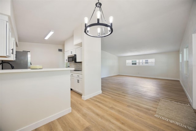 3813 Surrey Dr, Orlando, FL 32812 - kitchen featuring appliances with stainless steel finishes, backsplash, white cabinetry, light countertops, and light wood-style floors
