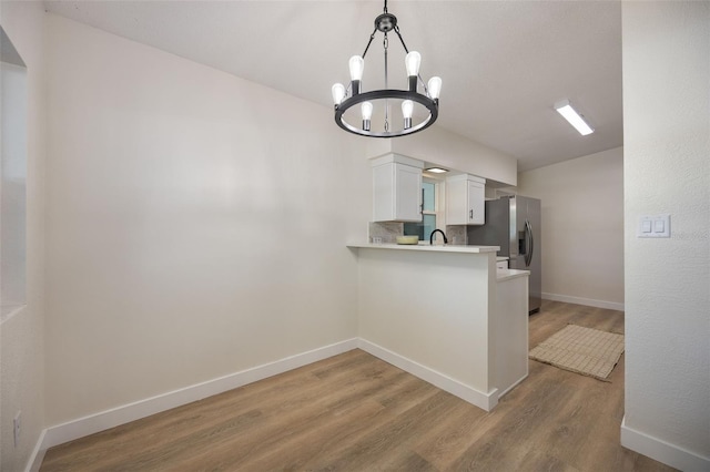 3813 Surrey Dr, Orlando, FL 32812 - kitchen with a chandelier, stainless steel refrigerator with ice dispenser, light wood-style flooring, light countertops, and baseboards
