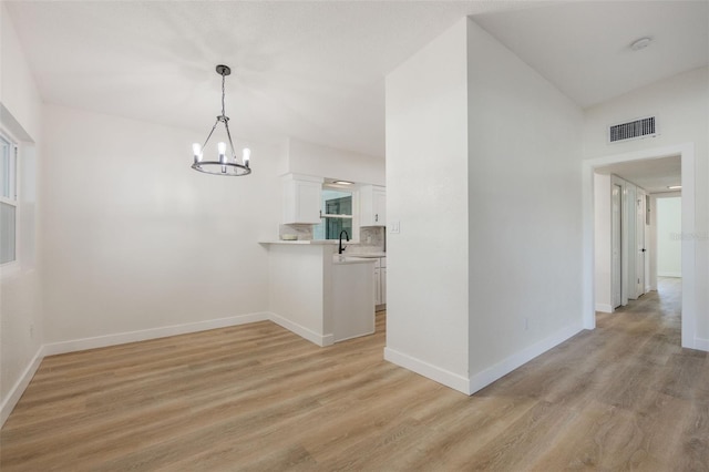 3813 Surrey Dr, Orlando, FL 32812 - unfurnished dining area with light wood-style flooring, a chandelier, baseboards, and a sink