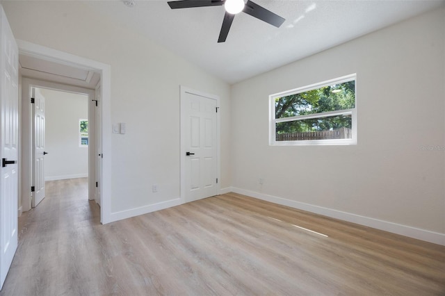 3813 Surrey Dr, Orlando, FL 32812 - unfurnished bedroom with multiple windows, light wood-style flooring, baseboards, attic access, and vaulted ceiling