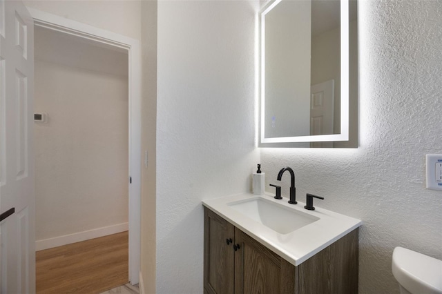 3813 Surrey Dr, Orlando, FL 32812 - half bathroom with toilet, vanity, wood finished floors, and baseboards