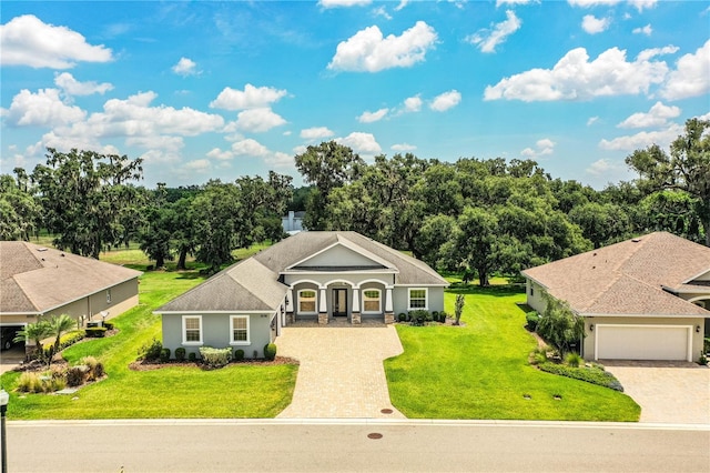 3176 Pearly Dr, Lakeland, FL 33812 - ranch-style house with decorative driveway, a front yard, stucco siding, and a garage
