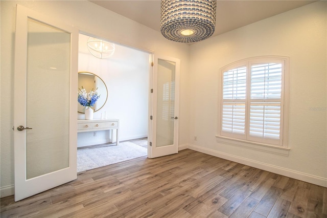 3176 Pearly Dr, Lakeland, FL 33812 - spare room featuring french doors, wood finished floors, a chandelier, and baseboards