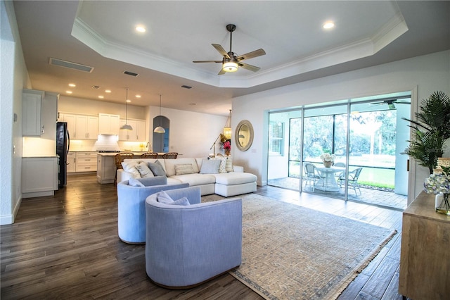 3176 Pearly Dr, Lakeland, FL 33812 - living room with a tray ceiling, ceiling fan, crown molding, dark wood finished floors, and recessed lighting
