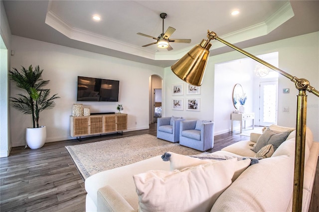 3176 Pearly Dr, Lakeland, FL 33812 - living room featuring a tray ceiling, arched walkways, ornamental molding, dark wood finished floors, and recessed lighting