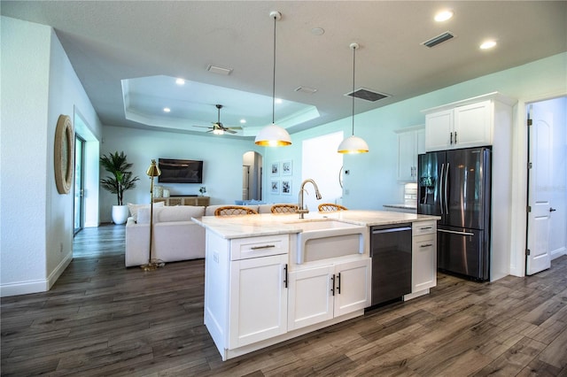 3176 Pearly Dr, Lakeland, FL 33812 - kitchen with black appliances, a raised ceiling, dark wood-style flooring, open floor plan, and white cabinets