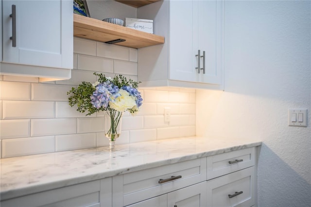 3176 Pearly Dr, Lakeland, FL 33812 - kitchen with open shelves, backsplash, white cabinets, and light stone countertops