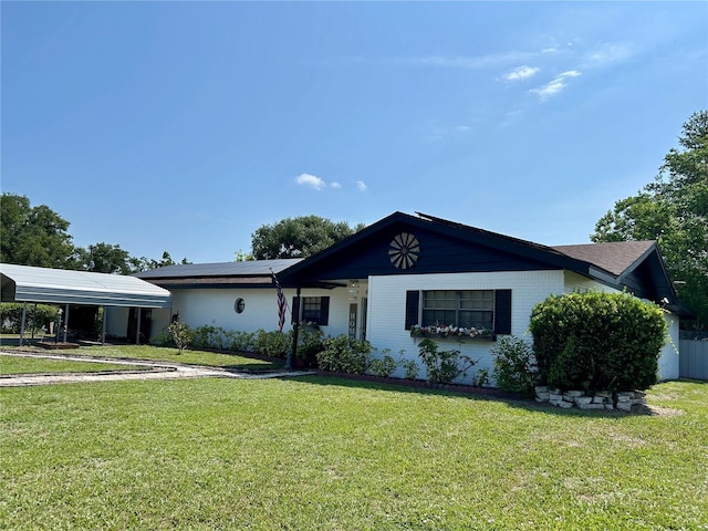 103 Inglis Way, Wauchula, FL 33873 - ranch-style house featuring solar panels, a carport, a front yard, and brick siding