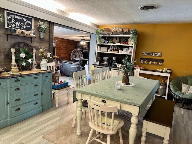 103 Inglis Way, Wauchula, FL 33873 - dining area featuring wooden walls, light wood-type flooring, and a textured ceiling