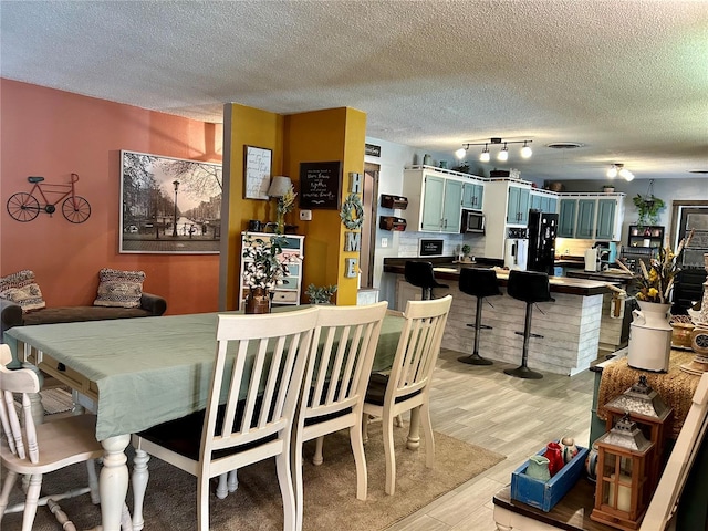 103 Inglis Way, Wauchula, FL 33873 - dining room featuring a textured ceiling, light wood-style flooring, and rail lighting
