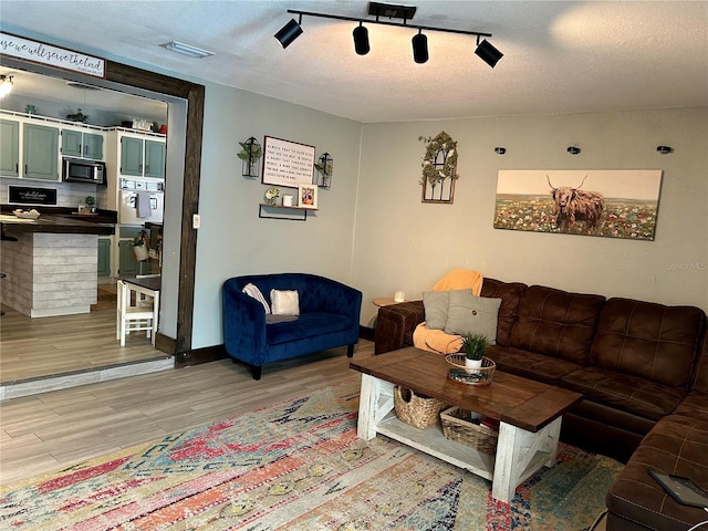 103 Inglis Way, Wauchula, FL 33873 - living room featuring light wood-type flooring, a textured ceiling, and baseboards