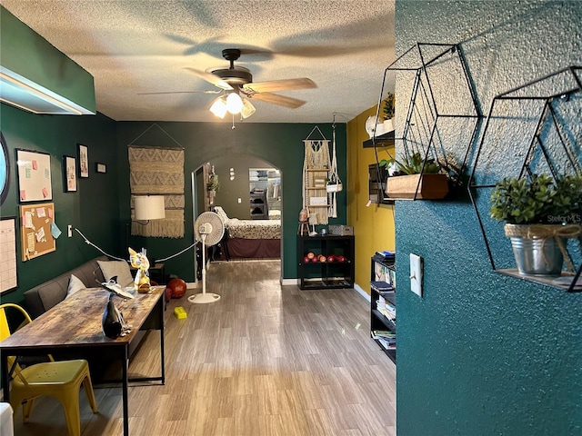 103 Inglis Way, Wauchula, FL 33873 - living room with arched walkways, a ceiling fan, wood finished floors, a textured ceiling, and baseboards