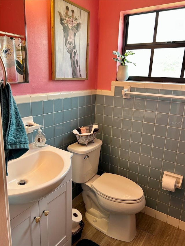 103 Inglis Way, Wauchula, FL 33873 - bathroom featuring tile walls, toilet, vanity, wainscoting, and wood finished floors