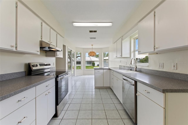 3618 Highland Fairways Blvd, Lakeland, FL 33810 - kitchen with stainless steel appliances, under cabinet range hood, a sink, white cabinets, and dark countertops