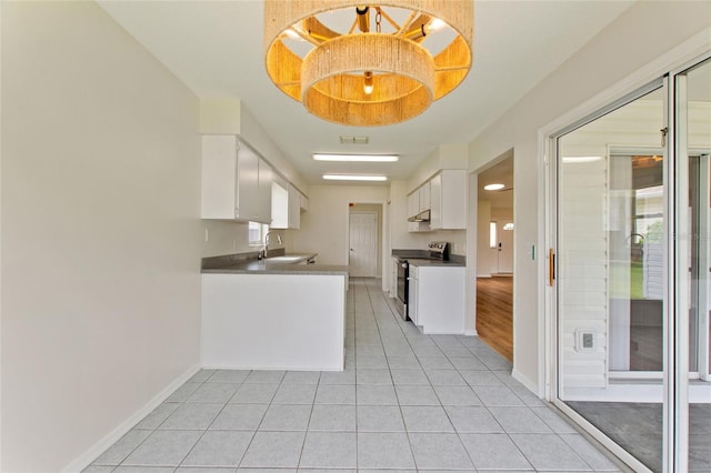 3618 Highland Fairways Blvd, Lakeland, FL 33810 - kitchen with stainless steel range with electric stovetop, baseboards, white cabinetry, and light tile patterned floors
