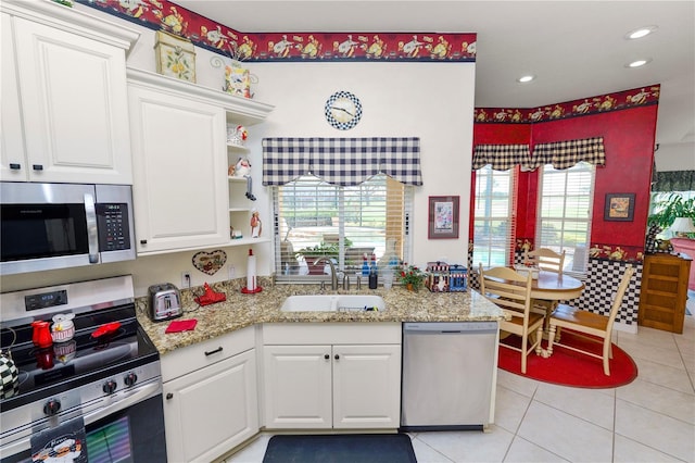 2936 Grasslands Dr, Lakeland, FL 33803 - kitchen with stainless steel appliances, a sink, white cabinetry, light tile patterned floors, and recessed lighting
