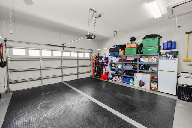 2936 Grasslands Dr, Lakeland, FL 33803 - garage featuring freestanding refrigerator and a garage door opener