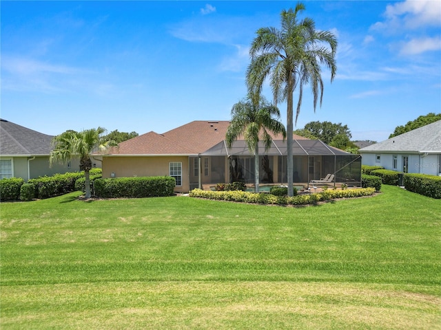 2936 Grasslands Dr, Lakeland, FL 33803 - back of house with a yard, glass enclosure, and stucco siding