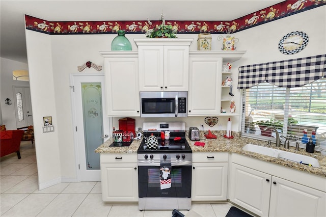 2936 Grasslands Dr, Lakeland, FL 33803 - kitchen with stainless steel appliances, a sink, light tile patterned floors, and white cabinets