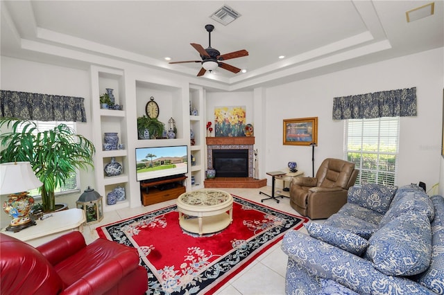 2936 Grasslands Dr, Lakeland, FL 33803 - tiled living area with a raised ceiling, built in features, a ceiling fan, a fireplace, and recessed lighting