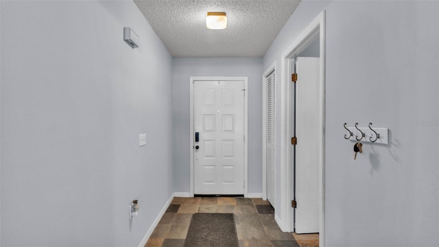 1423 Ridgegreen Loop N, Lakeland, FL 33809 - doorway to outside featuring a textured ceiling, baseboards, and stone finish flooring