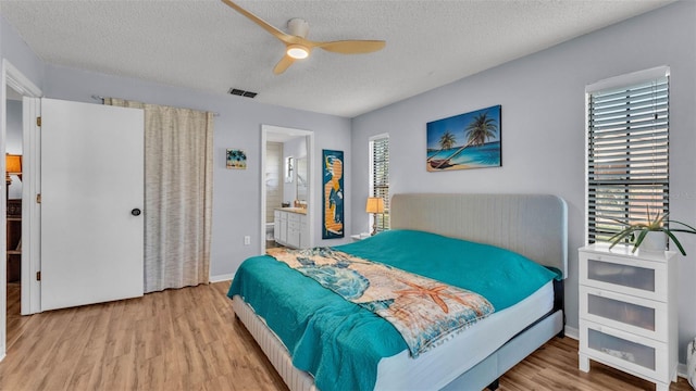1423 Ridgegreen Loop N, Lakeland, FL 33809 - bedroom with wood finished floors, a textured ceiling, multiple windows, a ceiling fan, and ensuite bath