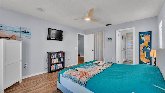 1423 Ridgegreen Loop N, Lakeland, FL 33809 - bedroom with wood finished floors, baseboards, a textured ceiling, ceiling fan, and ensuite bath