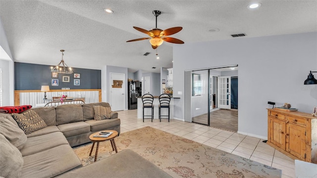 1423 Ridgegreen Loop N, Lakeland, FL 33809 - living room featuring a ceiling fan, light tile patterned flooring, lofted ceiling, a textured ceiling, and baseboards