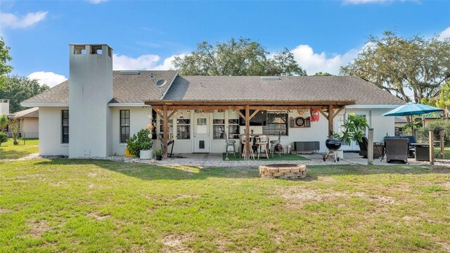 1423 Ridgegreen Loop N, Lakeland, FL 33809 - rear view of property featuring an outdoor fire pit, a patio area, a chimney, and a yard