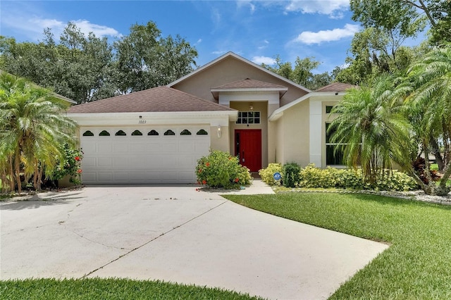 1003 Clearpointe Way, Lakeland, FL 33813 - view of front of property featuring an attached garage, concrete driveway, stucco siding, a front yard, and a shingled roof