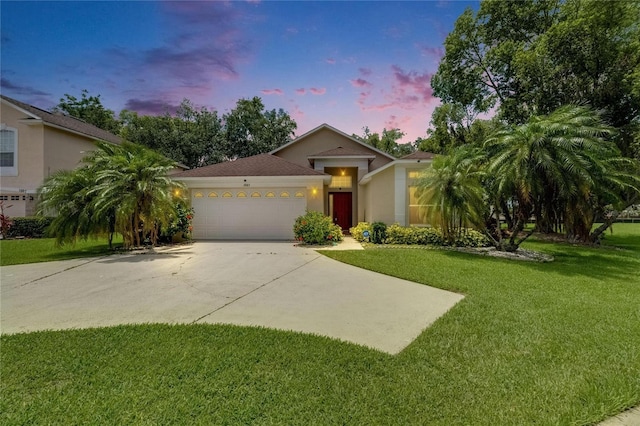 1003 Clearpointe Way, Lakeland, FL 33813 - view of front facade featuring driveway, a garage, a lawn, and stucco siding