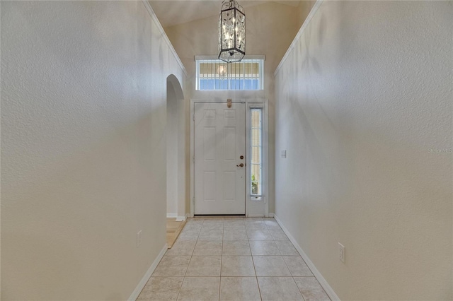1003 Clearpointe Way, Lakeland, FL 33813 - entrance foyer featuring arched walkways, a chandelier, light tile patterned flooring, baseboards, and a towering ceiling