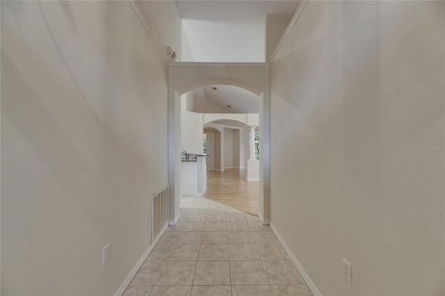 1003 Clearpointe Way, Lakeland, FL 33813 - hall featuring arched walkways, light tile patterned floors, and baseboards