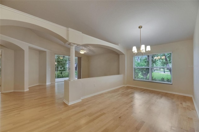 1003 Clearpointe Way, Lakeland, FL 33813 - unfurnished room with arched walkways, light wood-style flooring, decorative columns, a chandelier, and ornamental molding