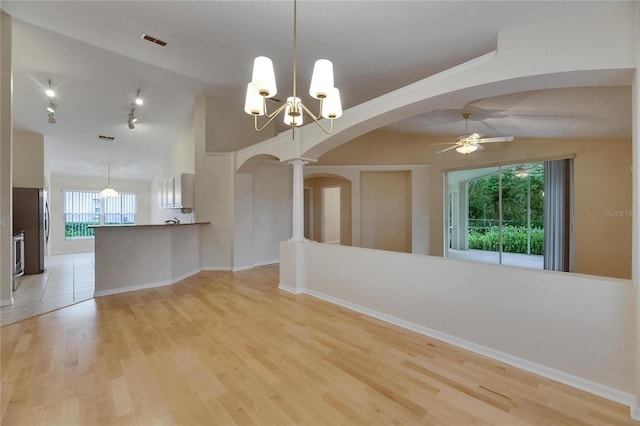1003 Clearpointe Way, Lakeland, FL 33813 - unfurnished dining area featuring arched walkways, a ceiling fan, lofted ceiling, a chandelier, and light wood-style flooring