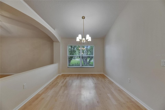 1003 Clearpointe Way, Lakeland, FL 33813 - empty room featuring wood finished floors, a chandelier, arched walkways, and baseboards