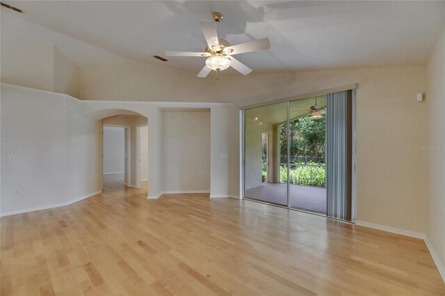 1003 Clearpointe Way, Lakeland, FL 33813 - empty room featuring lofted ceiling, arched walkways, wood finished floors, ceiling fan, and baseboards