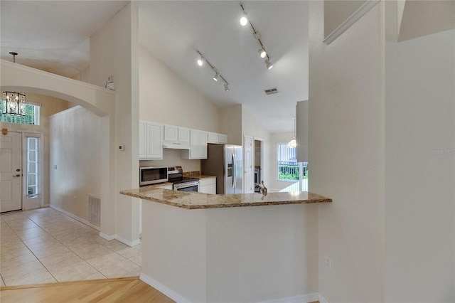 1003 Clearpointe Way, Lakeland, FL 33813 - kitchen featuring stainless steel appliances, high vaulted ceiling, white cabinetry, light stone counters, and healthy amount of natural light