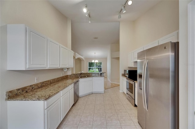 1003 Clearpointe Way, Lakeland, FL 33813 - kitchen featuring stainless steel appliances, a peninsula, white cabinetry, light tile patterned flooring, and light stone counters