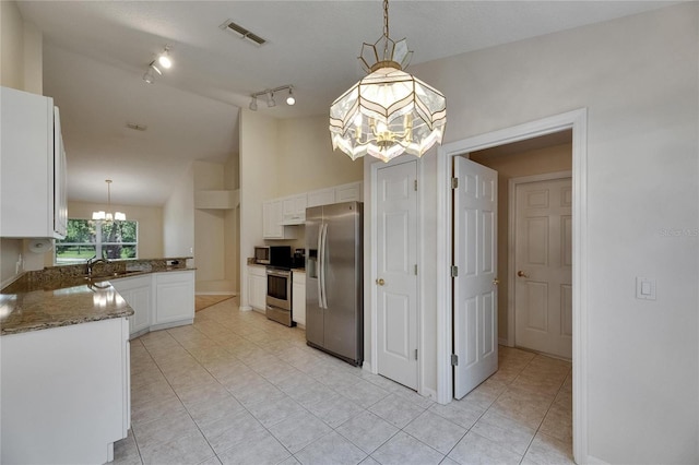 1003 Clearpointe Way, Lakeland, FL 33813 - kitchen featuring stainless steel appliances, a chandelier, light tile patterned flooring, white cabinets, and lofted ceiling