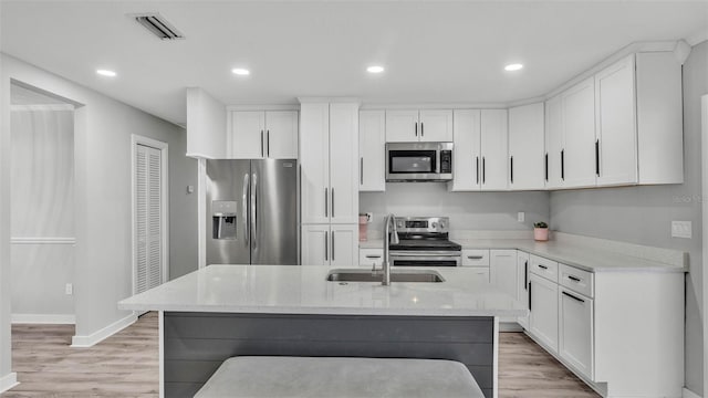 4825 Foxrun, Lakeland, FL 33813 - kitchen featuring stainless steel appliances, light wood-style floors, light stone counters, white cabinetry, and recessed lighting
