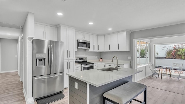 4825 Foxrun, Lakeland, FL 33813 - kitchen featuring stainless steel appliances, a sink, light wood finished floors, white cabinetry, and recessed lighting