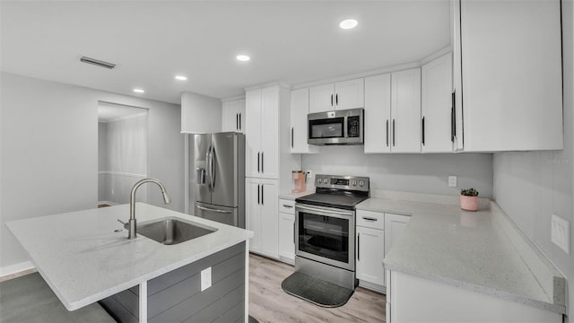 4825 Foxrun, Lakeland, FL 33813 - kitchen featuring stainless steel appliances, a sink, light wood-style flooring, light stone counters, and recessed lighting