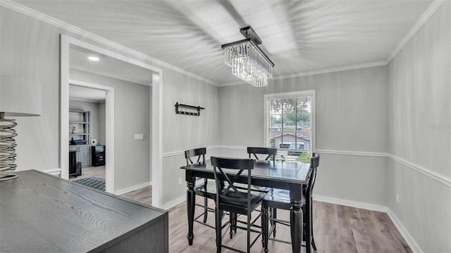 4825 Foxrun, Lakeland, FL 33813 - dining area with crown molding, light wood finished floors, a chandelier, and baseboards