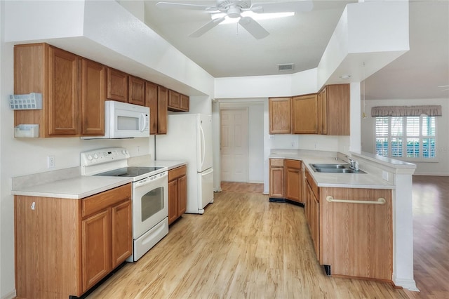 6065 Magpie Dr, Lakeland, FL 33809 - kitchen featuring white appliances, a sink, a peninsula, a ceiling fan, and light wood-style floors