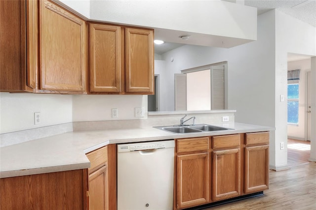 6065 Magpie Dr, Lakeland, FL 33809 - kitchen featuring white dishwasher, a sink, a peninsula, light countertops, and light wood finished floors