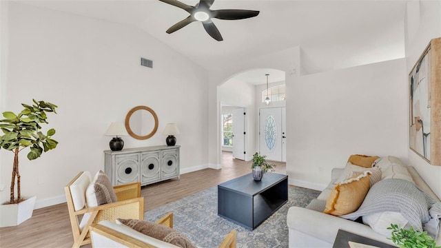5458 Oakford Dr, Lakeland, FL 33812 - living area featuring arched walkways, a ceiling fan, wood finished floors, high vaulted ceiling, and baseboards